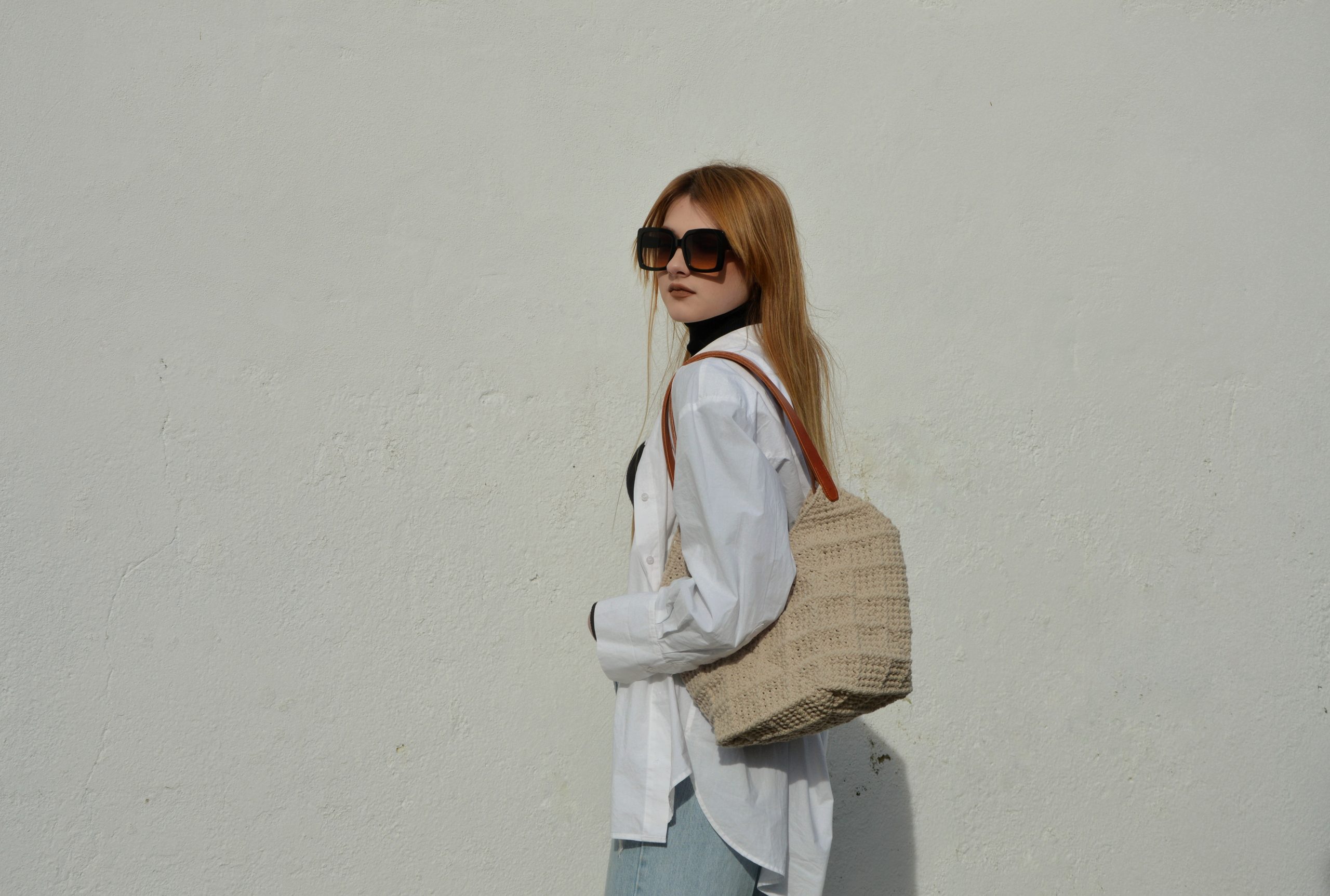 "'Windmill Bag' disponible por €350.00. Esta amplia bolsa artesanal está realizada en macramé con cuerdas de algodón sostenible certificado por OEKO-TEX, con asas de piel de curtido vegetal en color sol. Cada detalle de esta bolsa, desde las técnicas de macramé hasta las asas cosidas a mano con hilos de lino, refleja la artesanía y la calidad de los materiales utilizados."