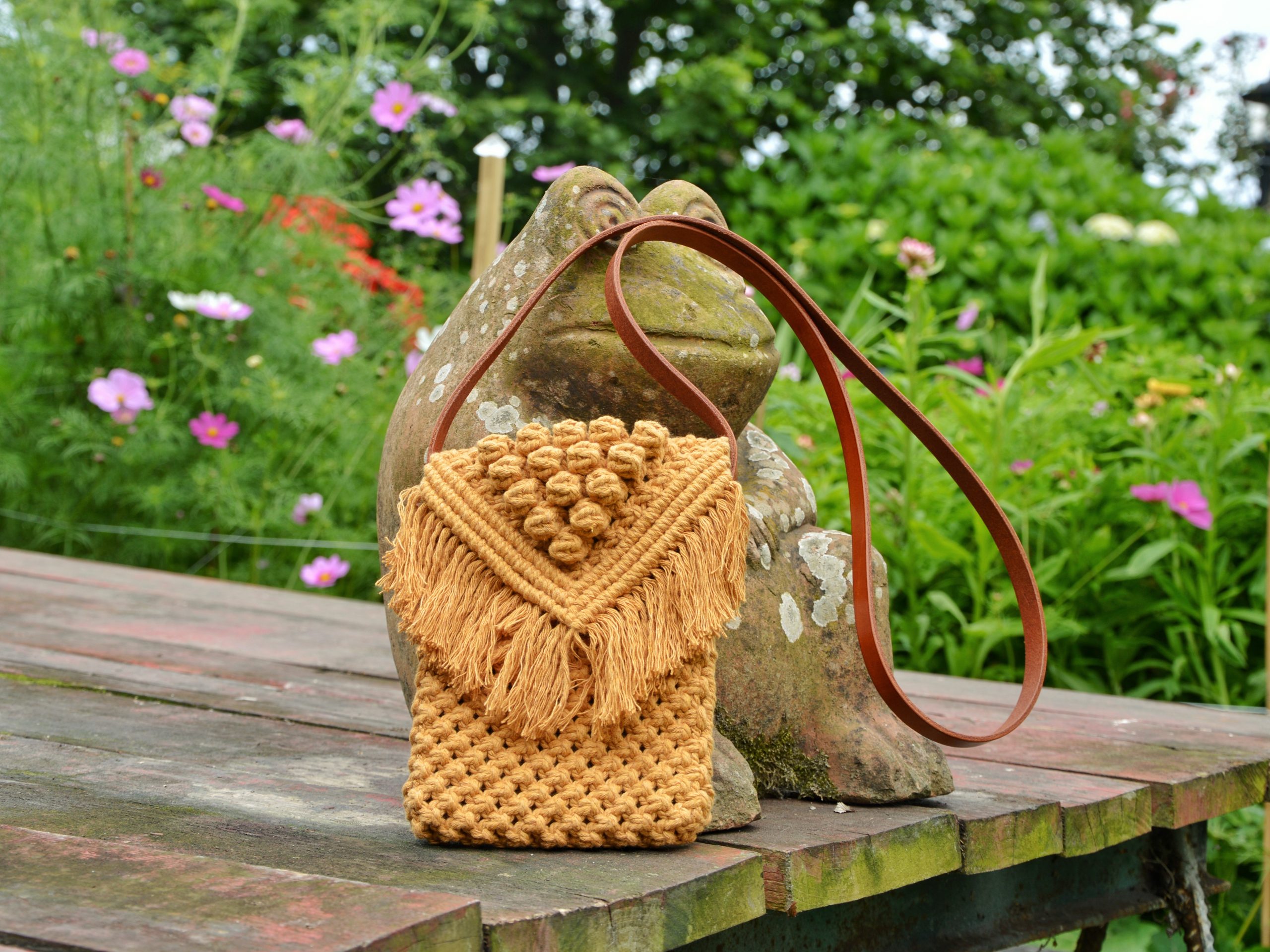"Cross Body Macramé disponible por €135.00. Esta bolsa cruzada está realizada en macramé con cuerdas de algodón sostenible certificado por OEKO-TEX, con una correa en piel de curtido vegetal. Sus dimensiones aproximadas sin correa son 19cm x 16 cm. Es una pieza artesanal que combina la técnica de macramé con la durabilidad y elegancia de la piel de curtido vegetal."
