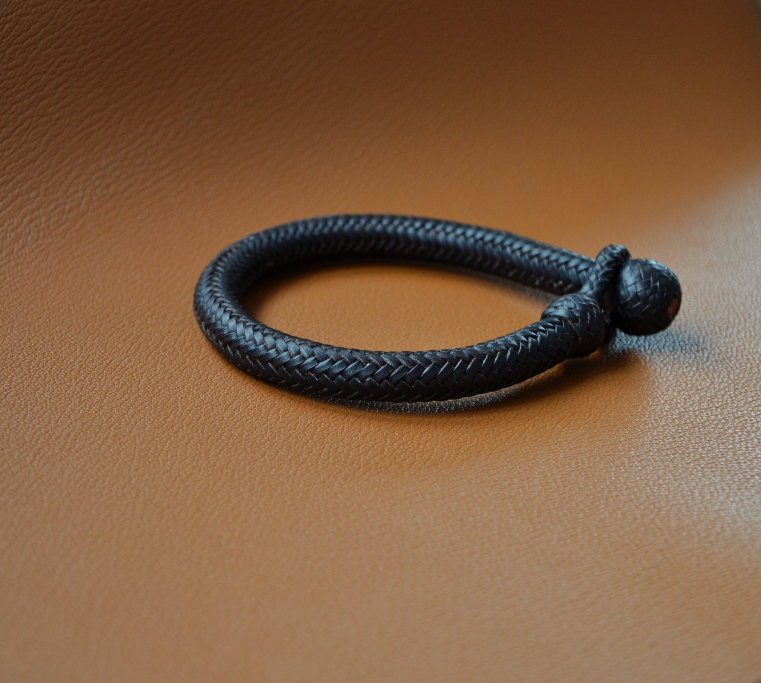 "Pulsera 16T Tubular disponible por €150.00. Elaborada con piel de curtido vegetal de color marrón tabaco, esta pulsera presenta una trenza única con alma maciza de cuero. Una pieza elegante y resistente que complementará tu estilo con un toque distintivo."
