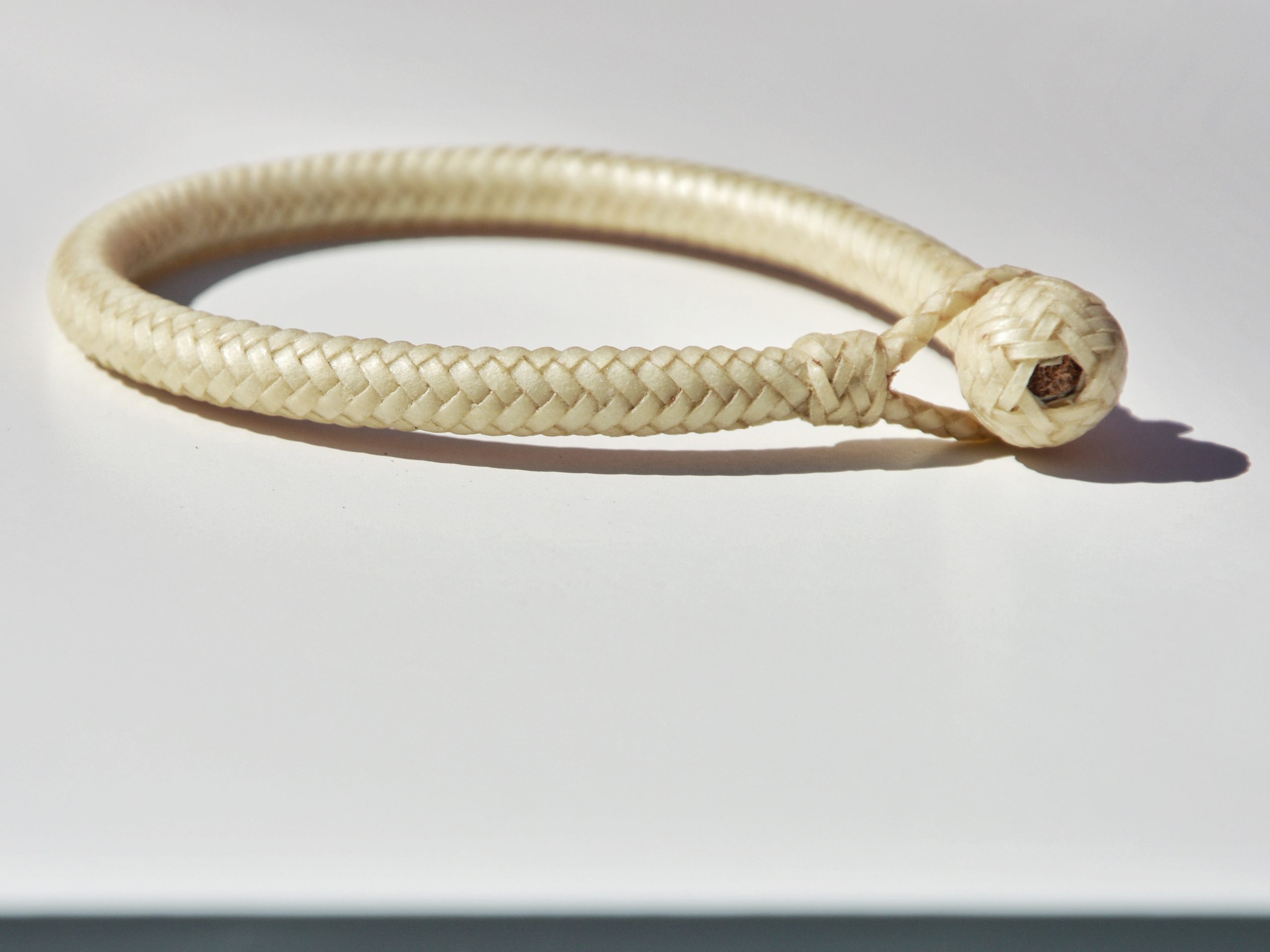 "Pulsera Cuero Crudo disponible por €115.00. Elaborada con técnicas de soguería criolla, esta pulsera está trenzada en cuero crudo con 12 tientos y terminaciones con retejidos. Las coloraciones obtenidas son a base de tintes naturales realizados previamente al trenzado. Es importante tener en cuenta que debido a su trenzado fino y natural, no se recomienda mojarla. Una pulsera que refleja la artesanía y la belleza de los materiales naturales."