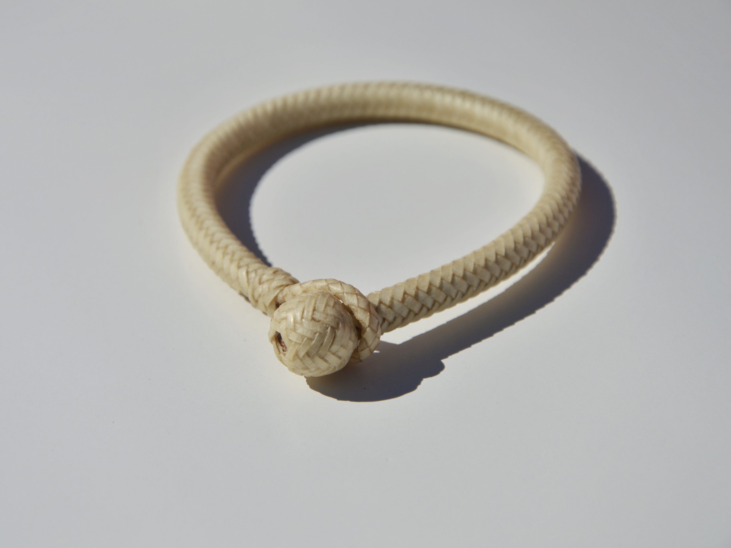 "Pulsera Cuero Crudo disponible por €115.00. Elaborada con técnicas de soguería criolla, esta pulsera está trenzada en cuero crudo con 12 tientos y terminaciones con retejidos. Las coloraciones obtenidas son a base de tintes naturales realizados previamente al trenzado. Es importante tener en cuenta que debido a su trenzado fino y natural, no se recomienda mojarla. Una pulsera que refleja la artesanía y la belleza de los materiales naturales."