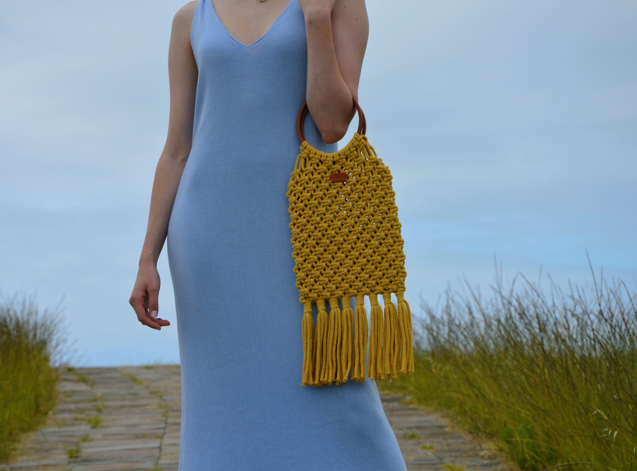 "Fringe Bag disponible por €115.00. Elaborada en macramé con cuerdas de algodón sostenible certificado por OEKO-TEX, y asas de piel de curtido vegetal en color sol. Una pieza artesanal con detalles únicos en su diseño y técnica de elaboración."
